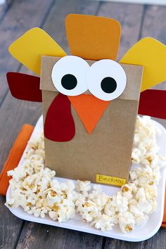 a paper turkey sitting on top of popcorn