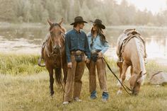 two men and a woman standing next to horses