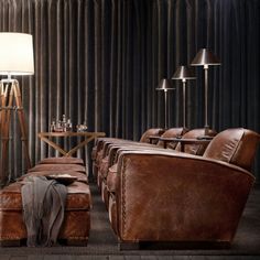 a living room filled with lots of brown furniture and tall lamps on top of them