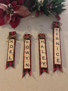 three wooden scrabbles with words on them sitting next to a flower arrangement