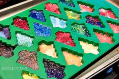 a tray filled with lots of different colored gummy bears sitting on top of a stove