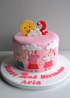 a peppa pig birthday cake with pink frosting and decorations on the top tier