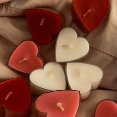 several heart shaped candles sitting on top of a bed