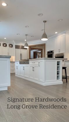 a large kitchen with white cabinets and an island