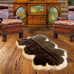 an animal skin rug is on the floor in front of two leather chairs