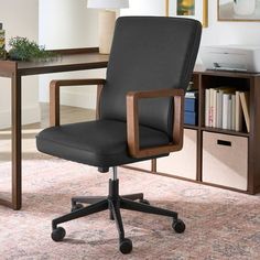 an office chair sitting in front of a desk with bookshelf and lamp on it