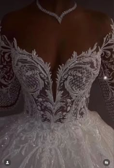 the back of a white wedding dress with sheer lace and beaded detailing on it