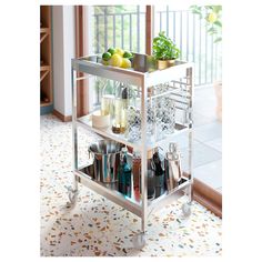 a kitchen cart filled with lots of bottles and glasses on top of a tiled floor