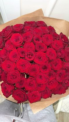 a person holding a bouquet of red roses