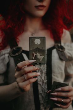 a woman with red hair holding up a card