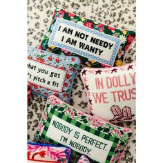 four cross stitch pillows with sayings on them