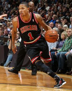 a basketball player dribbling the ball down the court during a game with fans watching