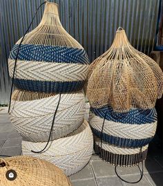 three woven baskets sitting on the ground next to each other, one is blue and white