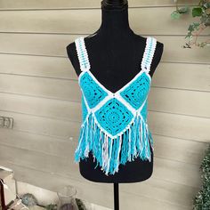 a mannequin wearing a blue and white crochet top with fringes