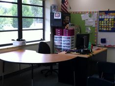 an empty desk in front of a large window