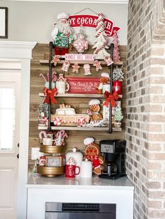 a kitchen counter topped with lots of christmas decorations and decorating items next to a brick wall