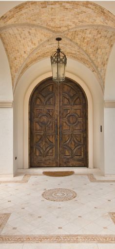 a large wooden door sitting in the middle of a hallway next to a light pole