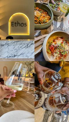 people holding wine glasses at a table with food and drinks