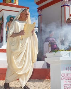 a man dressed in white holding a piece of paper