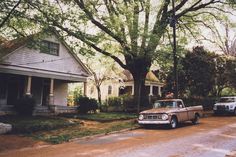 an old truck parked in front of a house