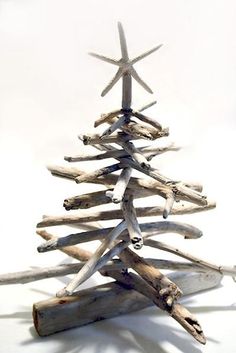 a christmas tree made out of driftwood on a white background with starfishs