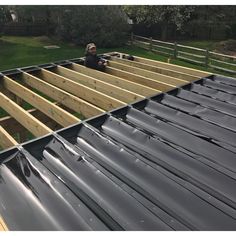 a man standing on top of a metal roof