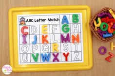 a yellow tray with letters and numbers on it next to a basket full of magnets