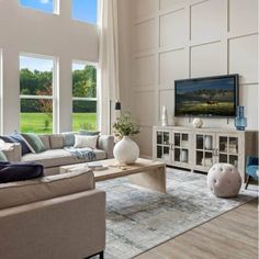 a living room filled with furniture and large windows