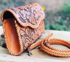 a brown leather purse sitting on top of a wooden table