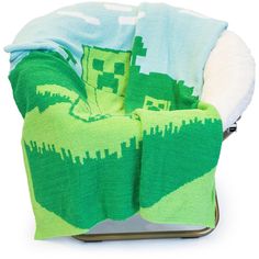 a chair covered in a blanket with an image of a minecraft creeper on it