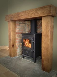 a wood burning stove sitting inside of a living room next to a fireplace mantel