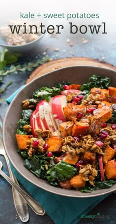 a bowl filled with kale, sweet potatoes and winter bowl on top of a table