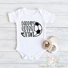 Introducing our adorable collection of baby bodysuits and toddler shirts! These charming and comfortable garments are perfect for your little ones to rock in style and comfort. Each piece is carefully crafted with love and attention to detail to ensure a delightful experience for both parent and child. 🌟 Key Features: 💜Superior softness: Made from premium, high-quality fabrics, our baby bodysuits and toddler shirts are incredibly soft and gentle on delicate skin. Your little bundle of joy will Cute White Onesie For Father's Day, Father's Day Casual Short Sleeve Onesie, Casual Cotton Onesie For Sports Events, Cotton Onesie With Letter Print For Sports Events, White Short Sleeve Fun Onesie, I Love Soccer, Football Onesie, New Baby Announcements, Football Baby