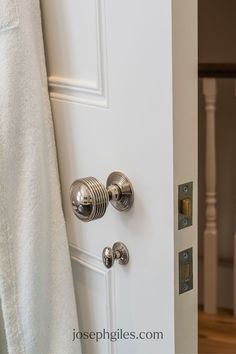 an open door with two knobs and a towel hanging on the front door handle