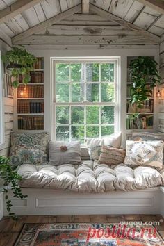 a white couch sitting under a window next to a rug