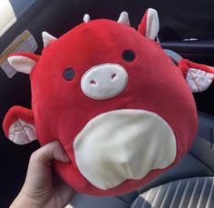 a red stuffed animal sitting on top of a car seat