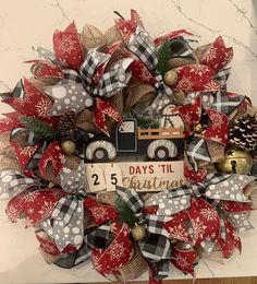 a christmas wreath with a truck and pine cones