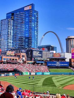 a stadium full of people with the st louis arch in the backgrouund