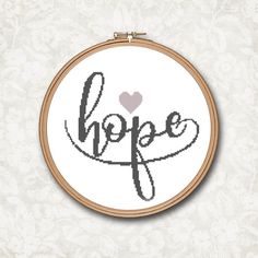 a cross stitch hoop with the word hope written in cursive writing