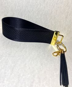 a black lanyard with gold hardware on a white background