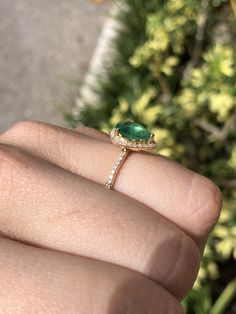 Featured is a stunning 1.43tcw natural teardrop Brazilian emerald and diamond halo engagement ring. The center gemstone is a genuine emerald handset in a 14K yellow gold prong setting. The emerald has a medium-green color and good eye clarity. Micro pave diamonds are placed delicately in the halo setting and mid-way down the shank. The diamonds are beautifully faceted and clean to the eye. Setting Style: Halo Setting Material: 14K Yellow Gold Main Stone: Emerald Shape: Pear Cut Measurements: 10 Teardrop Emerald Ring With Diamond Prong Setting, Green Diamond Ring Pear-shaped, Teardrop Emerald Ring With Diamonds, Fine Jewelry Teardrop Emerald Diamond Ring, Fine Jewelry Emerald Ring With Halo Setting, Pear-shaped, Emerald Teardrop Ring With Brilliant Cut, Teardrop Brilliant Cut Emerald Wedding Ring, Pear-shaped Emerald Ring With Halo Setting, Pear-shaped Halo Setting Ring For Proposal