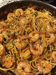 pasta with shrimp and parsley in a skillet on the stove top, ready to be cooked