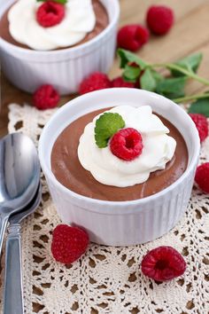 two small bowls filled with chocolate pudding and topped with raspberries