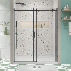 a bathroom with green and white tiles on the floor, shower stall doors are open