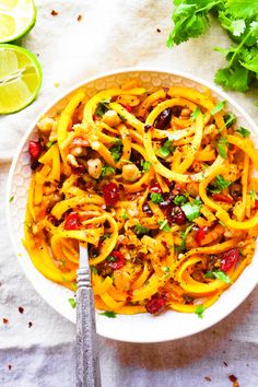 a white bowl filled with pasta and garnished with cilantro, parsley and mushrooms