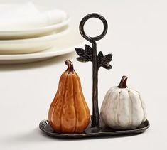 two small pumpkins sitting next to each other on a plate