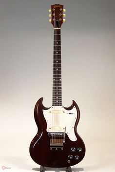 an electric guitar sitting on top of a stand