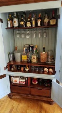 an open cabinet filled with liquor bottles and glasses