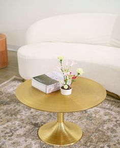 a white couch and table with flowers on it