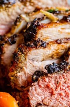 close up of meat and vegetables on a plate with carrots in the foreground